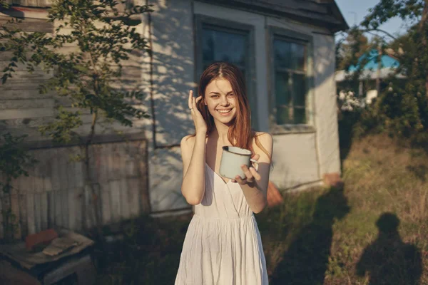 Όμορφη γυναίκα με μια κούπα στο χέρι εξοχικό σπίτι — Φωτογραφία Αρχείου