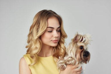 Sarı elbiseli bir kadın, küçük bir köpek manzaralı bir eğlence.