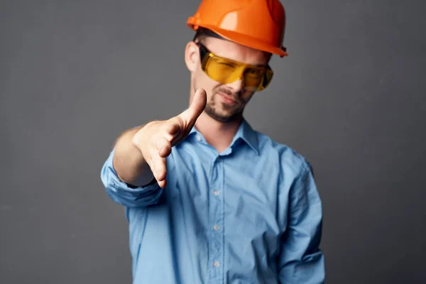 Homem em laranja chapéu duro design de construção camisa azul — Fotografia de Stock