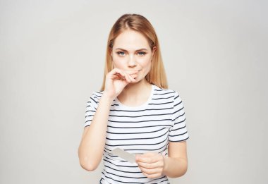 Çizgili tişörtlü güzel bir kadın. Reklam duyguları, el hareketleri.