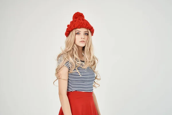 티셔츠를 입은 빨간 모자를 쓴 아름다운 여인 이 글 라머를 보고 있다 — 스톡 사진