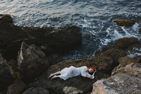 Hermosa mujer en vestido de novia blanco en la orilla del mar cabello mojado inalterado — Foto de Stock