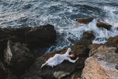 Beyaz gelinlikli kadın deniz kıyısında ıslak saçlı yaz tatili konsepti