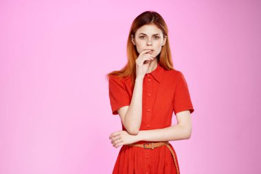 Güzel kadın kırmızı elbiseler pembe arka plan pozu
