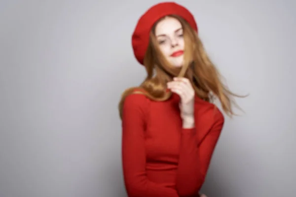 Веселая женщина с красной шапкой на голове гламурный светлый фон — стоковое фото