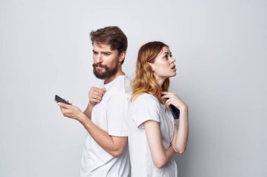 Beyaz tişörtlü erkek ve kadın ellerinde telefonlar stüdyo yaşam tarzı