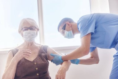 Tıbbi maskeli şırınga dokunulmazlığı olan bir doktor.