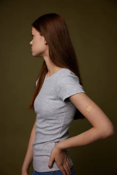 Kvinna i grå t-shirt hand med självhäftande gips vaccination hälsa immunitet — Stockfoto