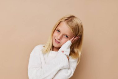 Güzel küçük kız elleriyle stüdyoya poz veriyor.