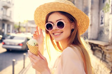 Güzel bir kadın dışarıda yürüyor. Dondurma yiyor. Seyahat modeli.