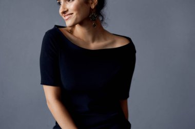 Siyah elbiseli güzel bir kadın lüks bir moda stüdyosunda.