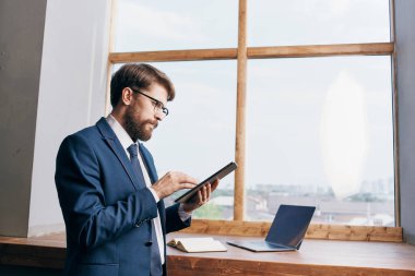 Pencere kenarındaki işadamları kendilerine güvenen tabletlerle.