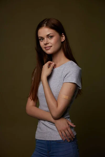 Vacker kvinna i grå t-shirt band-aid på hennes arm vaccin pass immunitet skydd — Stockfoto