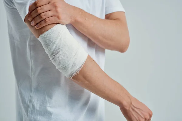 Enfermo hombre vendado mano lesión a los dedos aislado fondo —  Fotos de Stock