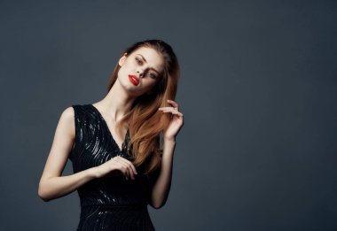 Siyah elbiseli güzel bir kadın izole edilmiş arka planda poz veriyor. Yüksek kalite fotoğraf