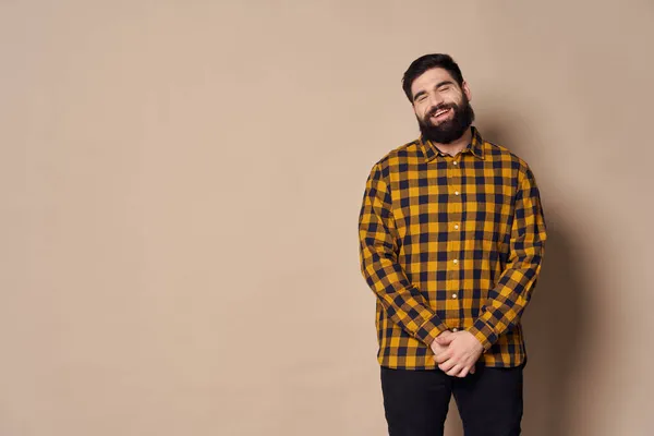 Fetter bärtiger Mann im karierten Hemd beige Hintergrund Kaffee Raum — Stockfoto