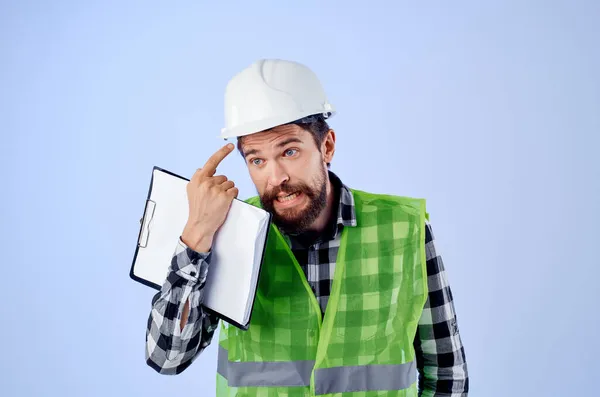 Мужчина строитель в зеленый вестибюль строительство работы дизайн синий фон — стоковое фото