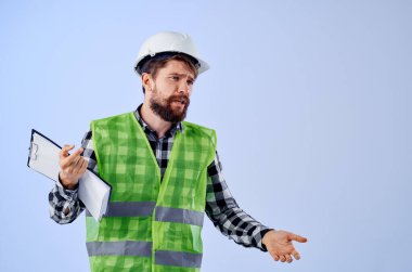 Beyaz kasklı bir erkek inşaatçı. Profesyonel mavi arka plan.