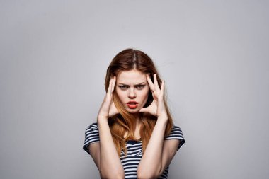 Güzel bir kadın, elinde saç makyajı ile komik bir model stüdyosunda poz veriyor.