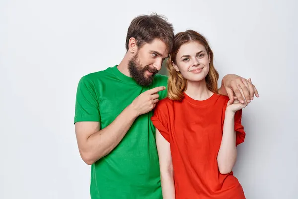 Мужчина и женщина обнимают красочные футболки семейного стиля жизни студии — стоковое фото