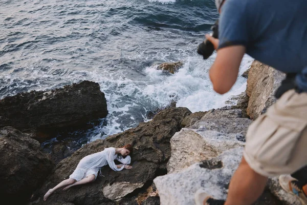 Женщина лежит на камне рядом с морским пейзажем — стоковое фото