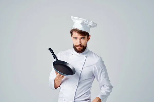 Un uomo in uniforme da chef con una padella in mano Professionista — Foto Stock
