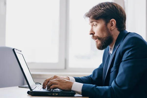 Homem no escritório na mesa na frente de um laptop tecnologias de carreira — Fotografia de Stock