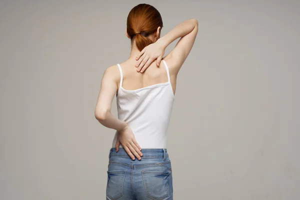 Beyaz tişörtlü kadın kayropraktik romatizma sağlık sorunları hafif arka plan — Stok fotoğraf