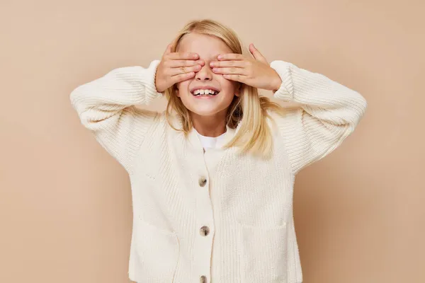 Porträt einer lächelnden kleinen Cutie mit blonden Haaren auf beigem Hintergrund — Stockfoto