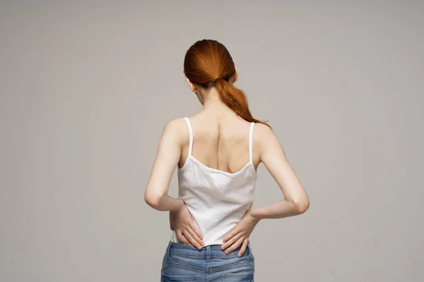 Nespokojená žena bolesti zad zdravotní problémy osteoporóza světlo pozadí — Stock fotografie