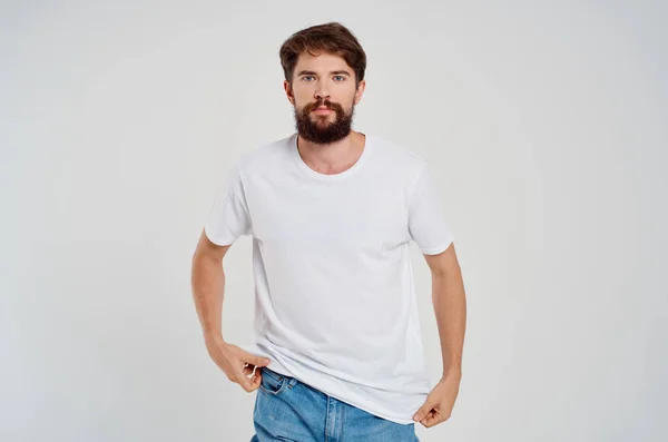 Carino uomo barbuto in bianco t-shirt studio di moda sfondo leggero — Foto Stock