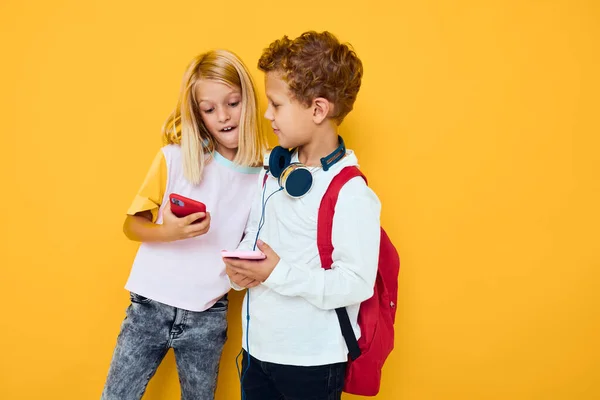 Foto von zwei kleinen Kindern Mädchen verwenden Gadgets mit Kopfhörern gelben Hintergrund — Stockfoto