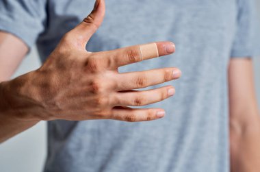 Sakallı adam bandajlı parmak tedavisi görüyor.