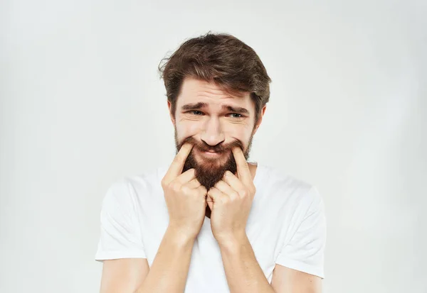 Triste homem em branco t-shirt emoções posando luz de fundo — Fotografia de Stock