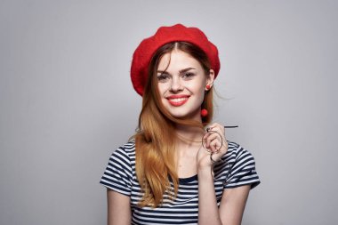 Kırmızı şapka takan neşeli bir kadın. Makyaj modası. Yaşam tarzı.