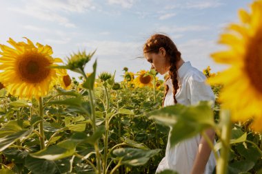 Beyaz elbiseli iki örgülü kadın doğaya hayran.