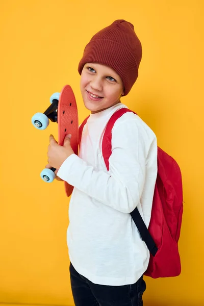 Legal sorrindo menino no um branco suéter skate entretenimento cor amarela fundo — Fotografia de Stock