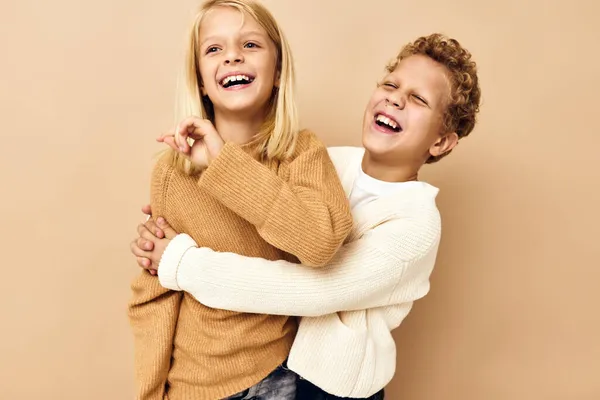 Lindo elegante niños abrazo juegos sonrisa amistad beige fondo —  Fotos de Stock