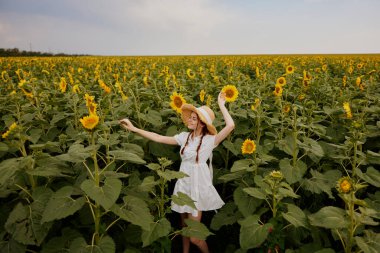 At kuyruklu kadın yaz zamanı ayçiçeği tarlasına bakıyor.