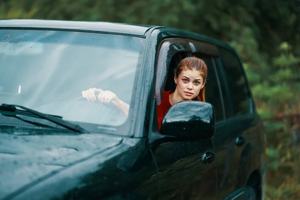 Jovem mulher dirigindo carro olhando para fora da janela corte vista — Fotografia de Stock