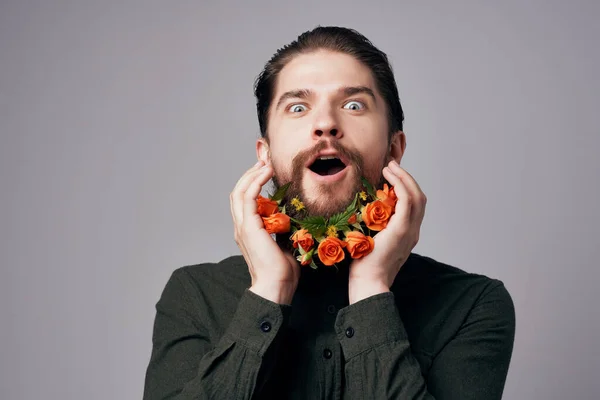 Красивый мужчина позирует с цветами в бороде — стоковое фото
