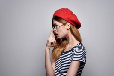 Çizgili tişörtlü bir Fransız kadın. Kırmızı dudaklı. Yazın elleriyle hareket ediyor.