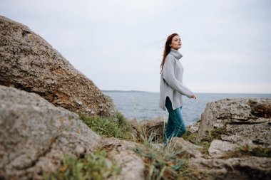 Kadın plaj turizmi bulutlu hava taşlı kıyı rahatlama konsepti