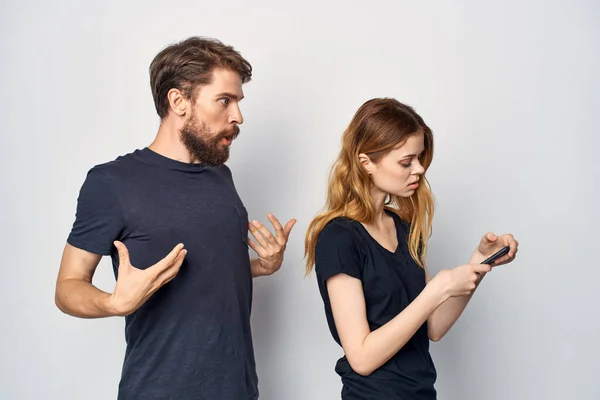 Чоловік і жінка в чорних футболках телефон весело разом дружба ізольований фон — стокове фото