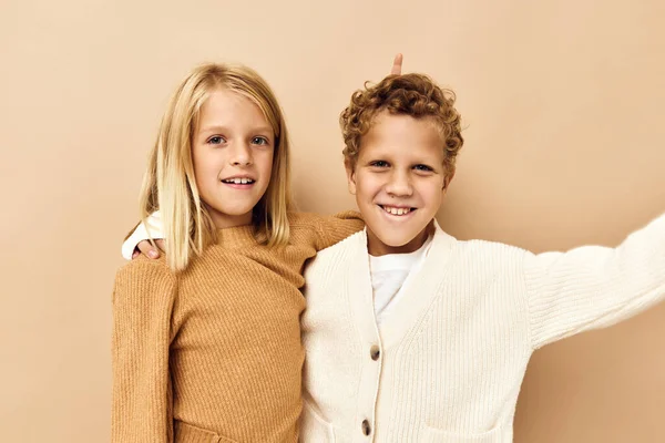 Niño y niña en suéteres de fondo beige —  Fotos de Stock