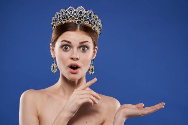Çıplak bir kadının portresi. Mücevher estetiği çekici. Mavi arka plan.