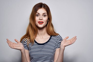 Çizgili tişörtlü güzel bir kadın, elleri izole edilmiş.