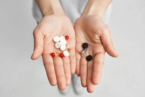 Sick woman pills in hand pain reliever light background — Stock Photo, Image