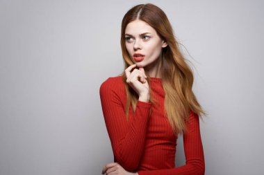 Kırmızı elbiseli güzel bir kadın lüks bir el hareketi yapıyor.