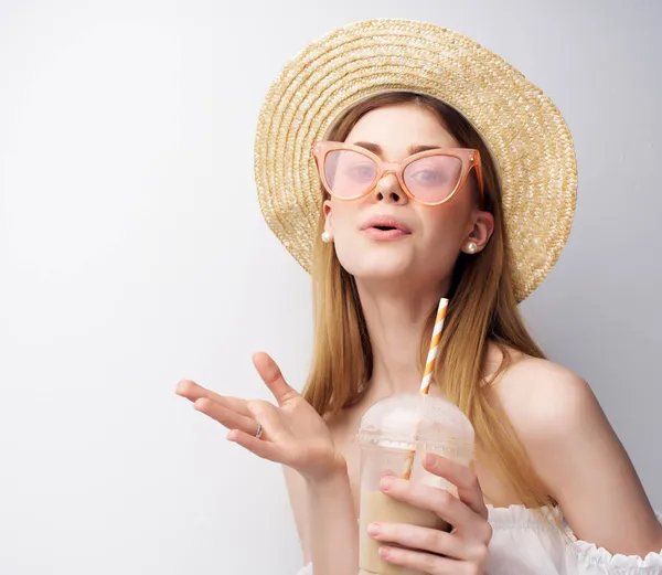 Attrayant femme dans des lunettes de chapeau à la mode verre avec boisson posant — Photo
